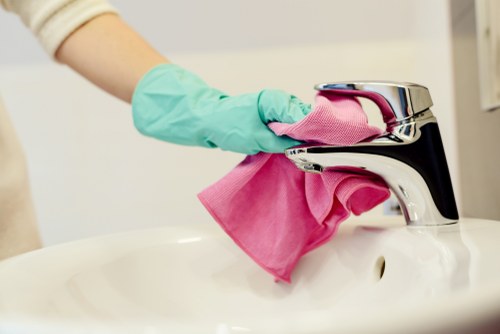 Domestic cleaner tidying a kitchen during domestic cleaning in N16